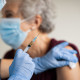 Doctor makes vaccination to senior woman with surgical mask